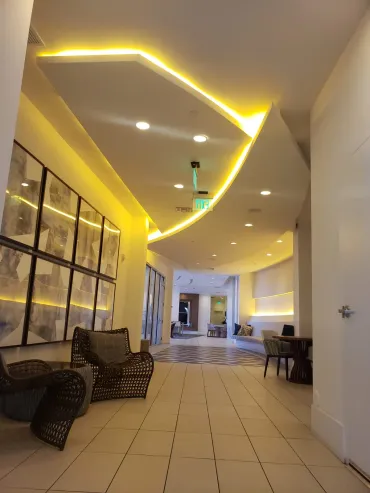 Finished lobby ceiling with an angular cove-lit drop soffit