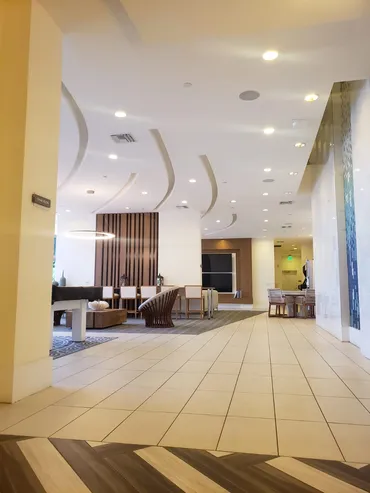 Lobby with curved ceiling fins and recessed lighting, fully finished