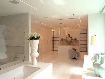 Finished ceilings with recessed lighting in a marble bathroom and corridor