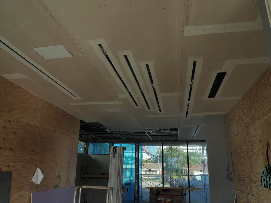Drywall ceiling with linear light slots, taped and ready for finish