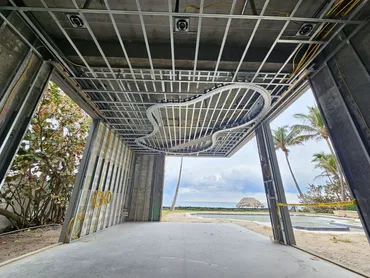 Curved metal framing for a sculpted ceiling detail at an open-air entry
